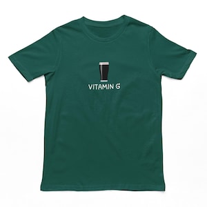 May include: A dark green t-shirt with a white graphic of a glass of beer and the text "Vitamin G".