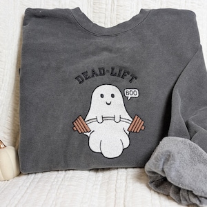Könnte beinhalten: Grauer Pullover mit einem Geist, der Gewichte hebt, und dem Text "DEAD-LIFT BOO".