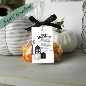 May include: A white tag with black text that reads "Happy Halloween While you're enjoying this candy remember that I'm just around the corner for any real estate questions! - Your Realtor" attached to a clear cellophane bag filled with candy corn.