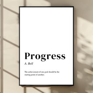 Puede incluir: Impresión enmarcada en blanco con la palabra "Progress" en negrita negra. Debajo, "A. Bell" y la cita: "El logro de un objetivo debería ser el punto de partida de otro."