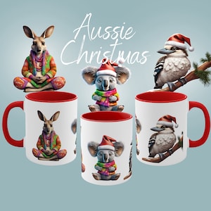 May include: White ceramic mugs with red interiors and handles, featuring Australian animals in festive attire. The mugs display a kangaroo, koala, and kookaburra, all wearing Christmas hats and scarves. The text "Aussie Christmas" is above the mugs.