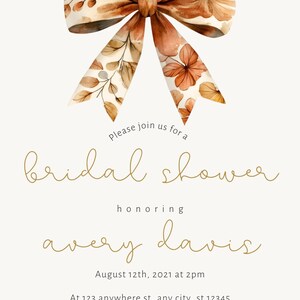 May include: A bridal shower invitation with a watercolor bow in shades of brown and orange. The invitation reads "Please join us for a bridal shower honoring Avery Davis. August 12th, 2021 at 2pm. At 123 anywhere st., any city, st 12345. Please RSVP to 123.456.7890"