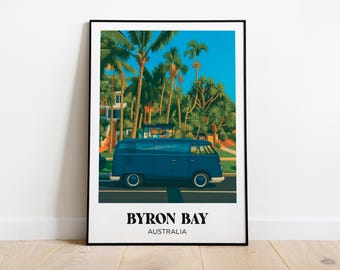 Puede incluir: Una impresión artística enmarcada que muestra una furgoneta azul vintage conduciendo por una carretera bordeada de palmeras bajo un cielo azul brillante. El texto "BYRON BAY AUSTRALIA" está impreso en blanco en la parte inferior.