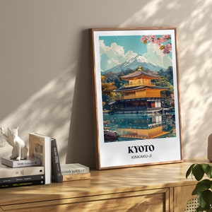 Pu&ograve; includere: Una stampa incorniciata di un tempio dorato riflesso in uno stagno tranquillo, con il Monte Fuji sullo sfondo. La stampa &egrave; intitolata "Kyoto Kinkaku-ji".