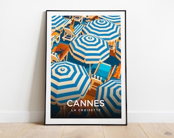 Puede incluir: Lámina artística enmarcada que representa una escena de playa en Cannes, Francia. La obra muestra sombrillas a rayas azules y blancas, tumbonas y el texto "Cannes La Croisette."