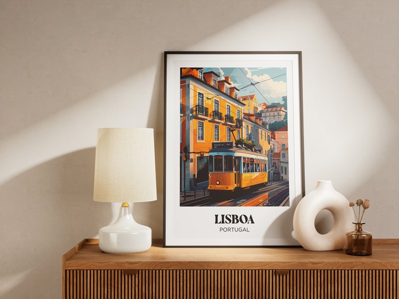 May include: A framed print of a yellow tram traveling up a hill in Lisbon, Portugal. The print features colorful buildings and a blue sky. The text "LISBOA PORTUGAL" is at the bottom of the print.