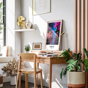 Pu&ograve; includere: Un ambiente di lavoro domestico con una scrivania in legno, una sedia e una stampa incorniciata di una citt&agrave; con la scritta "TOKYO" su di essa. Ci sono piante, una lampada e libri sulla scrivania.