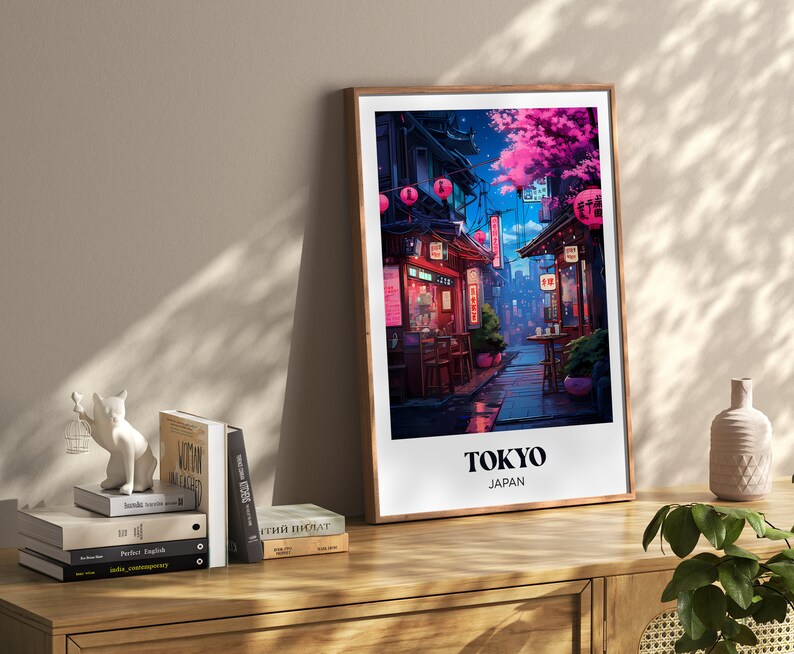 Pu&ograve; includere: Una stampa incorniciata di un'illustrazione colorata di una strada a Tokyo, Giappone. La strada &egrave; fiancheggiata da edifici e negozi, e ci sono persone che camminano. La stampa &egrave; in una cornice di legno e ha il testo "TOKYO GIAPPONE" in basso.
