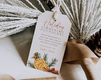 Peut inclure: Une étiquette blanche avec le texte "Holiday Simmering Potpourri" en écriture brune. L'étiquette contient des instructions pour faire du pot-pourri et indique "Homemade by: Sophia Jackson". L'étiquette est décorée d'une illustration aquarelle d'oranges, de bâtonnets de cannelle et de branches de pin.