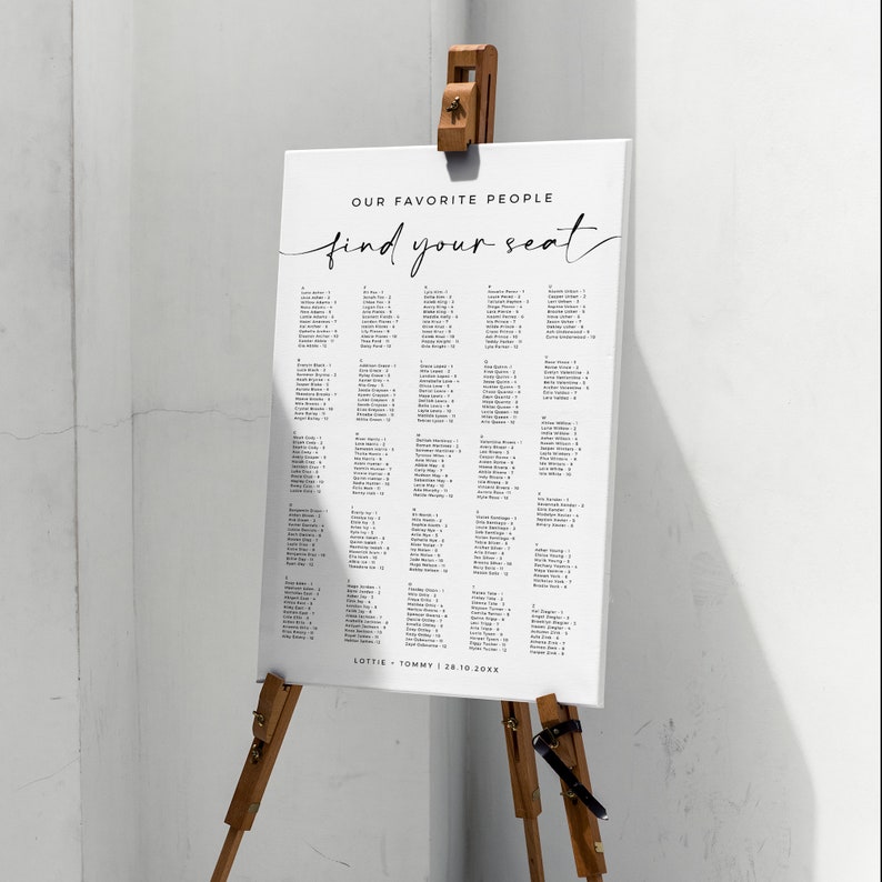 May include: A white wedding seating chart with black text. The chart is titled "Our Favorite People find your seat". The chart lists names and table numbers. The bottom of the chart reads "Lottie + Tommy | 28.10.20XX".