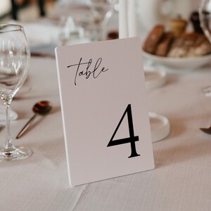 May include: White table number card with black text that reads "Table 4".