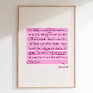Könnte beinhalten: Ein weißer gerahmter Druck mit einer rosa hervorgehobenen Passage aus Psalm 23. Der Text lautet: "Der HERR ist mein Hirte, mir wird nichts fehlen. Er weidet mich auf grünen Auen und führt mich an stillen Wassern. Er erquickt meine Seele. Er führt mich auf rechten Pfaden, um seines Namens willen. Und wenn ich auch durch das finstere Tal gehen muss, fürchte ich kein Unheil, denn du bist bei mir; dein Stab und deine Stange, die geben mir Trost. " Psalm 23