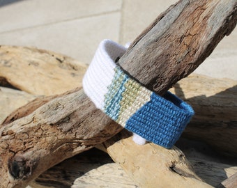 Handwoven bracelet-half white and half ocean blue base with blue, green, beize elements in center