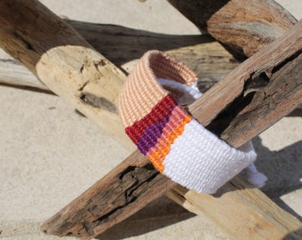 Handwoven bracelet-half white and half beize base with maroon, purple, pink and orange elements in center