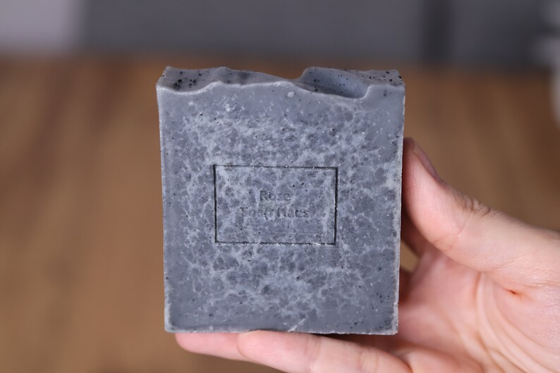 May include: A gray bar of soap with a black label that reads "Rose Soap Notes".