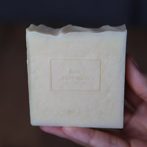 May include: A white bar of soap with the words "Rose Soap Haus" embossed on the front.