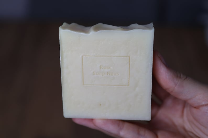 May include: A white bar of soap with the words "Rose Soap Haus" embossed on the front.