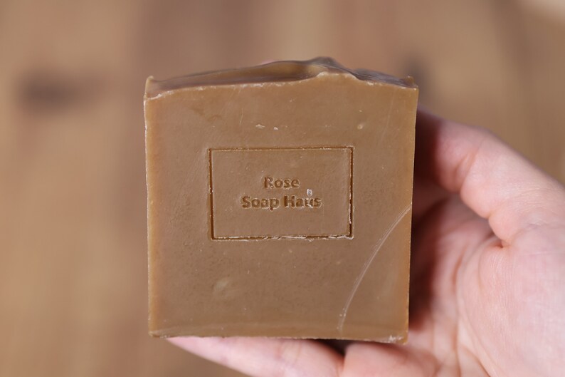 May include: A brown bar of soap with the text "Rose Soap Haus" embossed on the front.