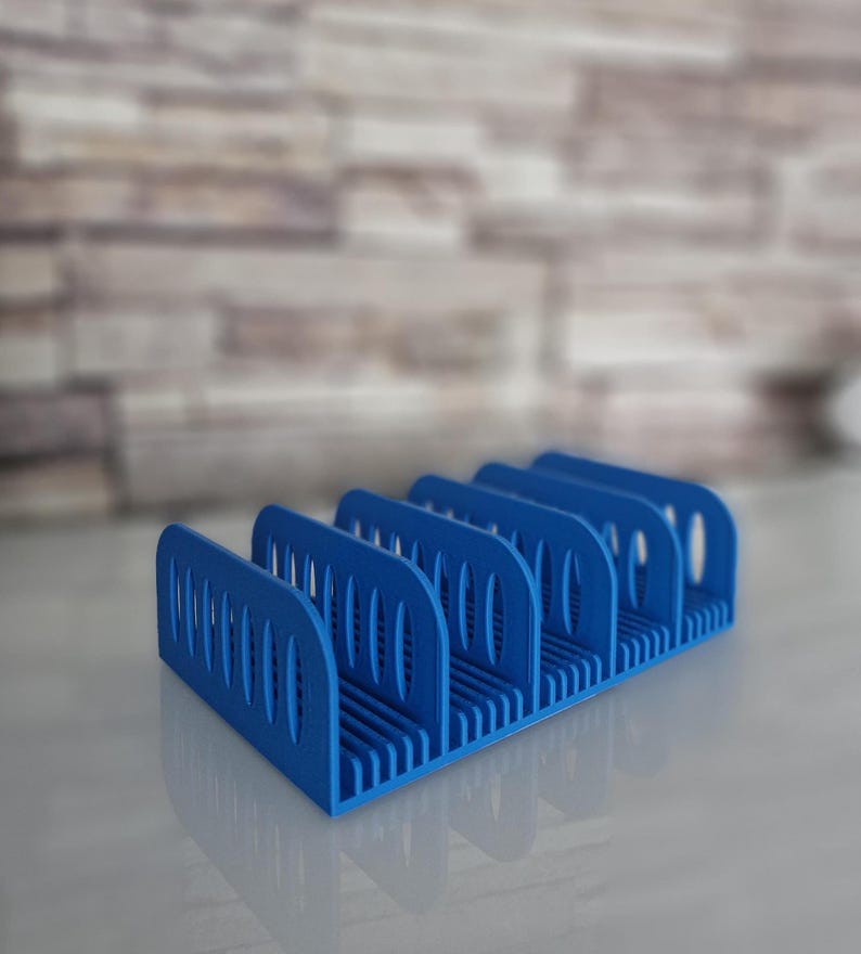 May include: A blue plastic organizer with five compartments for holding items like pens, pencils, or other small objects.