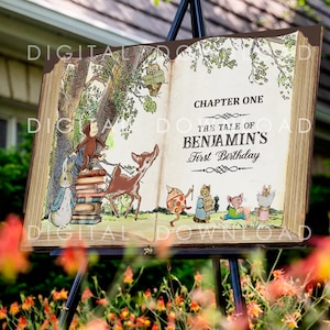 May include: A decorative wooden book-shaped sign with illustrations of storybook characters. The sign reads "The Tale of Benjamin's First Birthday" with "Chapter One" at the top. The sign is displayed on a black easel.