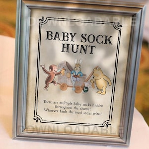 May include: Framed sign with the text "BABY SOCK HUNT" and illustrations of a monkey, a rabbit, and a bear. The sign's text reads, "There are multiple baby socks hidden throughout the shower. Whoever finds the most socks wins!"