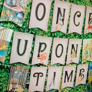 May include: A banner with the words "Once Upon A Time" in black letters on a light pink background. Each letter is on a separate flag with illustrations from children's books.