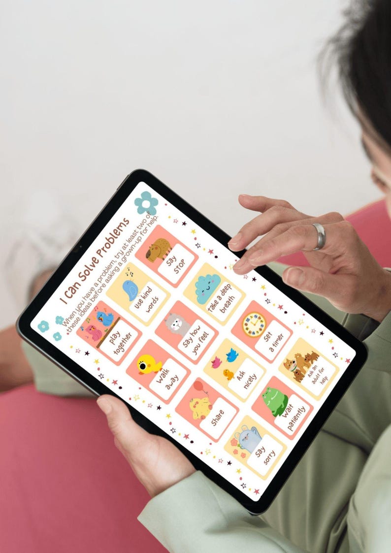 May include: A tablet displaying a colorful educational chart titled "I Can Solve Problems." The chart features illustrated suggestions like "use kind words" and "take a deep breath." The tablet is held by a person.