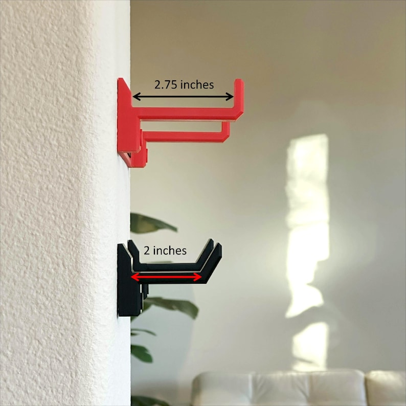 Pode incluir: Dois ganchos de parede, um vermelho e outro preto. O gancho vermelho mede 2,75 polegadas de largura e o gancho preto mede 2 polegadas de largura.