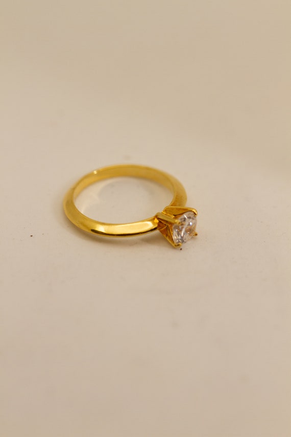 Gold tone round cut faux diamond ring, glass stone