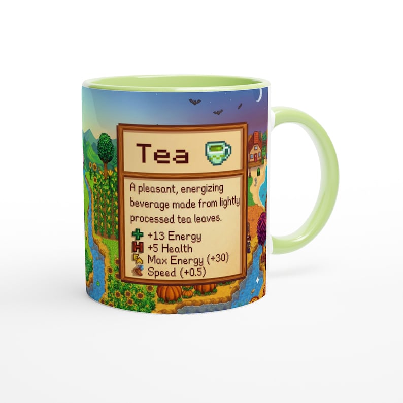May include: A ceramic mug with a light green handle and interior. The mug features a colourful landscape design with a river, trees, and a house. The mug has the word "Tea" and a description of the beverage.