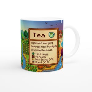 May include: White ceramic mug with a colourful landscape design, including a river, trees, and a house. The mug displays the word "Tea" and a description of the beverage, with energy and health benefits, in a pixelated style.