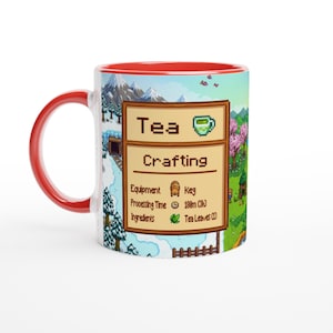 May include: A ceramic mug with a red handle and interior. The mug features a pixelated design with the words "Tea Crafting" and a graphic of a tea cup. The design includes a snowy mountain scene and a green field.