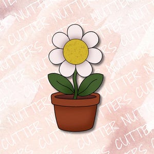 Può includere: Un tagliabiscotti a forma di fiore in vaso con un vaso color terracotta marrone, due foglie verde scuro, un sottile stelo verde e un fiore bianco con un centro giallo testurizzato. Il design è piatto con un contorno ben definito.