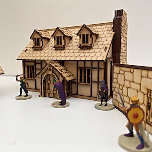 May include: A wooden model of a medieval cottage with a thatched roof, a door, and windows. The cottage is surrounded by a stone wall with a gate. There are five miniature figures standing in front of the cottage.
