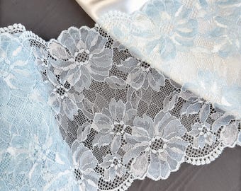 Könnte beinhalten: Nahaufnahme von zarter hellblauer Spitze mit Blumenmuster. Die Spitze hat einen gewellten Rand.