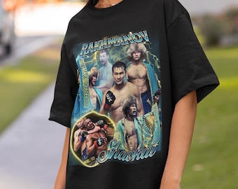 May include: A black short-sleeve t-shirt featuring a graphic print of MMA fighter Shavkat Rakhmonov. The design includes multiple images of the athlete, yellow lightning accents, and the text RAKHMANOV and Shavkat in a stylized blue font.