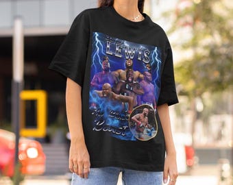 May include: A black short-sleeve t-shirt featuring a graphic print of Derrick Lewis. The design includes multiple images of the fighter, blue lightning bolts, and the text "Derrick Lewis" and "The Black Beast" in a metallic silver font.