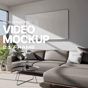 Puede incluir: Un salón moderno con un sofá seccional gris, una mesa de centro negra y una gran ventana. En la pared hay un marco rectangular blanco. El texto de la imagen dice "VIDEO MOCKUP 2:1 FRAME".