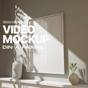 Puede incluir: Una maqueta de marco blanco con un jarrón blanco y un jarrón con plantas verdes en un estante blanco. El texto "VIDEO MOCKUP" está escrito en blanco sobre un fondo gris. El texto "DIN A FRAME" está escrito en blanco sobre un fondo gris.