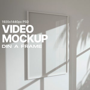 May include: A white picture frame mockup on a white wall with shadows from a window. The text "VIDEO MOCKUP" and "DIN A FRAME" is visible below the frame.