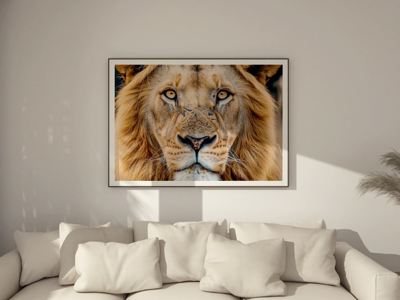 May include: Close-up portrait of a lion with a golden mane. The lion's eyes are focused on the viewer, and its expression is intense.