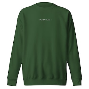 Könnte beinhalten: Ein dunkelgrüner Pullover mit dem Aufdruck "PO-TA-TOES" in Weiß auf der Vorderseite.
