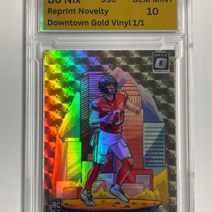 May include: A white ceramic mug with a black handle and the text "But First, Coffee" in a black, handwritten-style font. The mug is on a white surface.