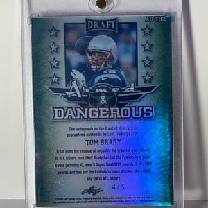 Puede incluir: Tarjeta de f&uacute;tbol de Tom Brady, en un soporte protector. La tarjeta muestra a Brady con el uniforme de los Patriots, con las palabras "Armed & Dangerous" y "DRAFT". La tarjeta est&aacute; numerada 4/5. Autenticidad garantizada por Leaf Trading Cards.
