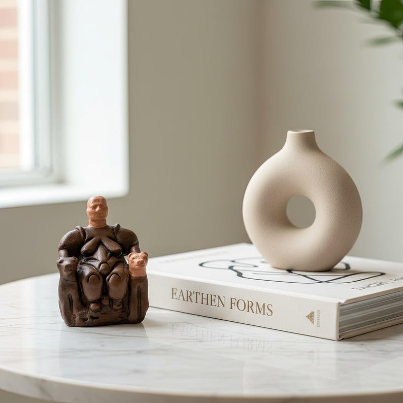 Cybele Goddess figurine displayed on a rustic wooden desk beside pottery and dried flowers. The natural setting evokes the atmosphere of an ancient shrine, symbolizing fertility and harmony. A perfect handmade art piece for boho or archaeology-inspired home decor.