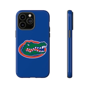 May include: A blue phone case with a green alligator head logo in an orange circle. The case is designed for an iPhone with a camera bump.