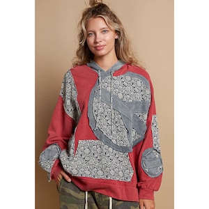 May include: Red patchwork hoodie with a floral pattern and a large peace sign design. The hoodie has a drawstring hood and a kangaroo pocket.