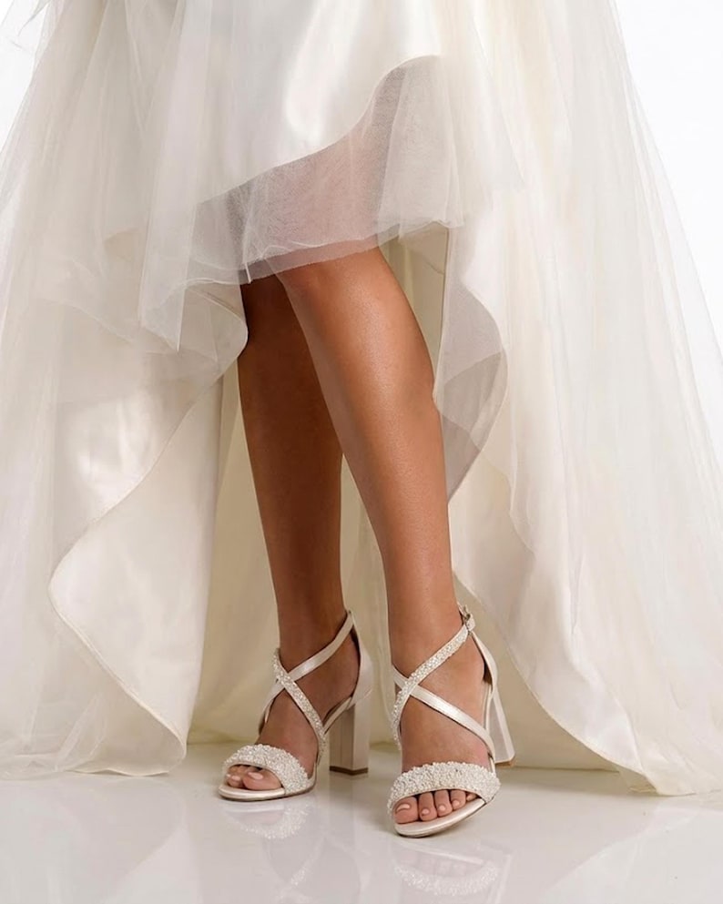 Elegant ivory wedding shoes with pearl accents and supportive block heel for all-day wear.
