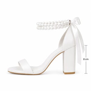 White bridal sandals with double pearl ankle straps displayed inside a YvollaShoes wedding shoe box with luxury bridal details.