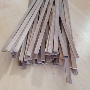 Op de afbeelding: Een stapel dunne, lichtbruine houten stroken, waarschijnlijk voor knutsel- of houtbewerkingsprojecten.